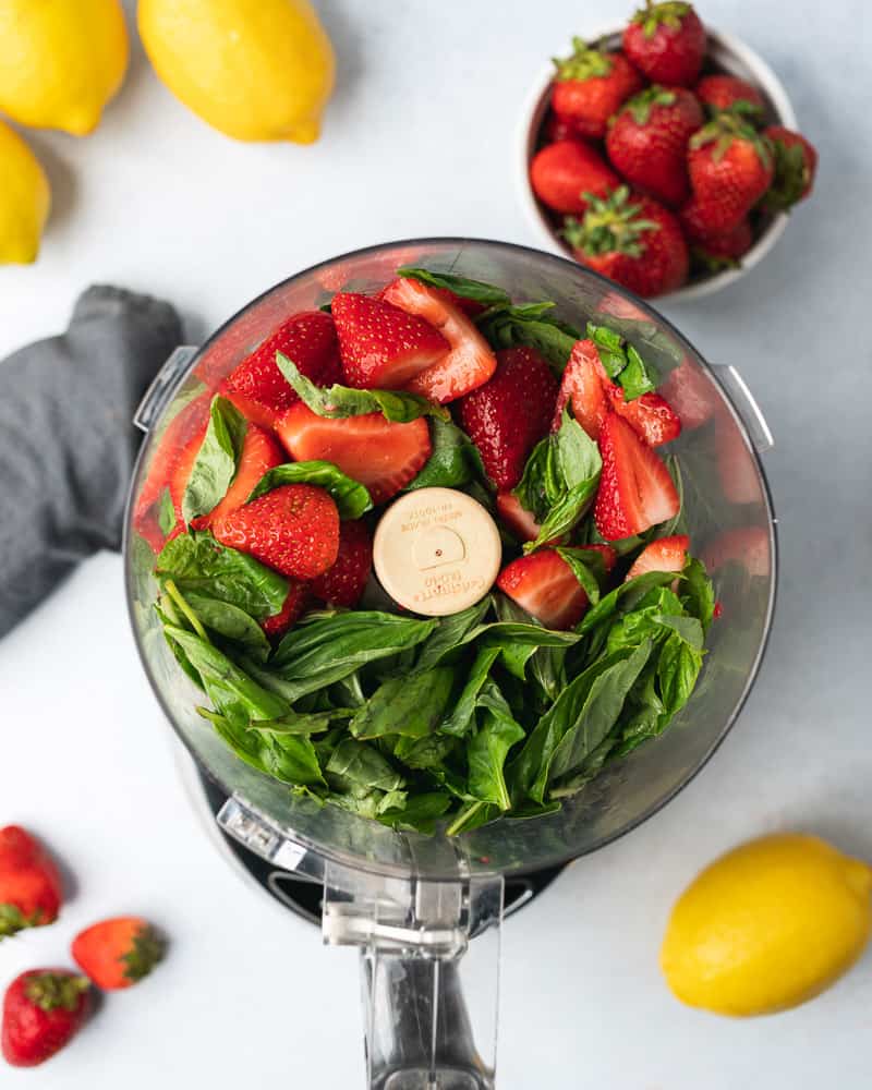 fresh strawberries and basil in a food processor with lemons