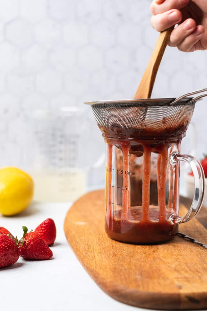 straining strawberry basil puree