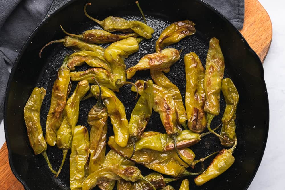 shishito peppers roasted in a cast iron skillet