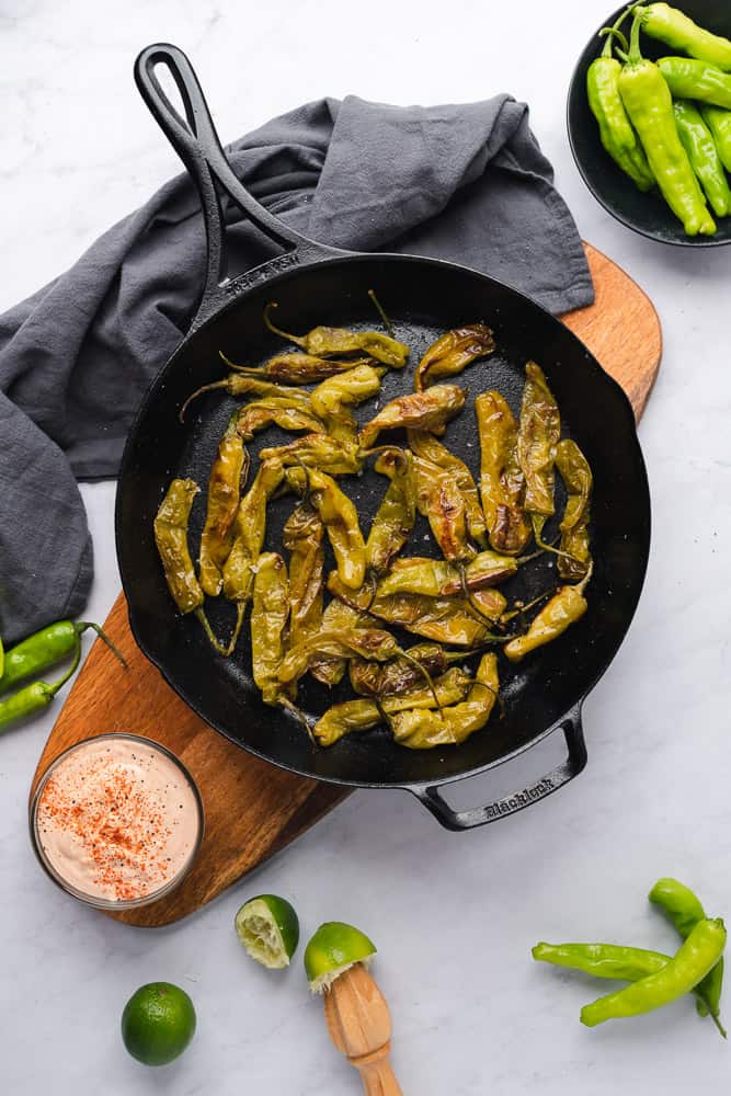 roasted shishito peppers with creamy aioli in a cast iron skillet