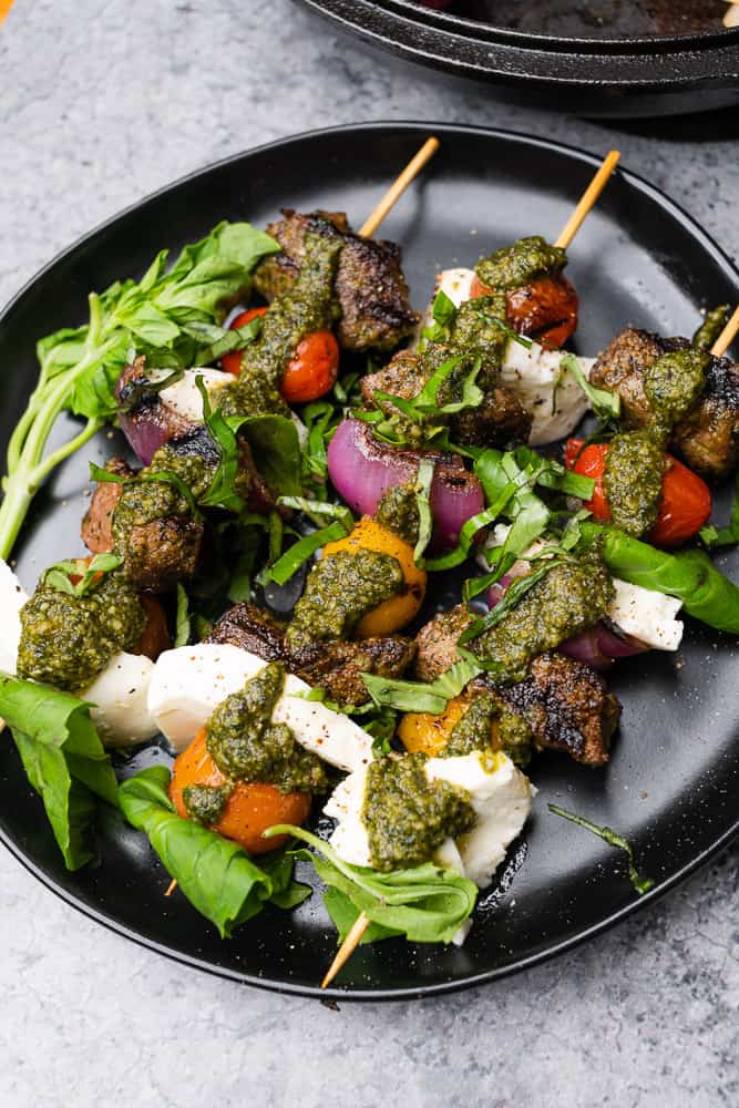 steak skewers with red onions, mozzarella, basil, and pesto