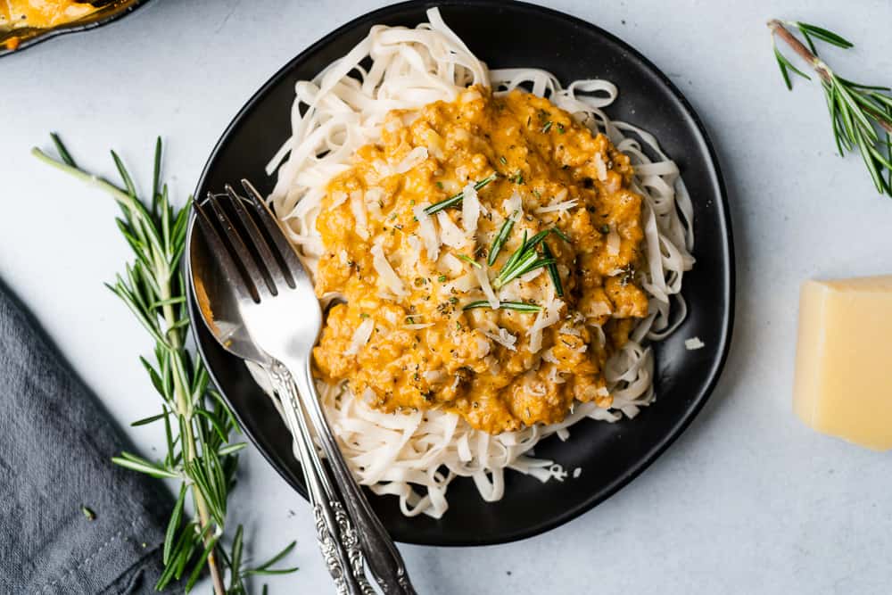 black plate of pumpkin pasta with rosemary