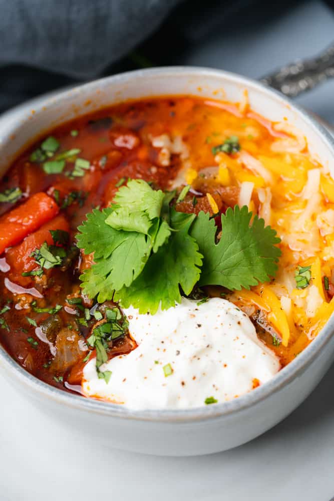 large dollop of sour cream on chili with cilantro