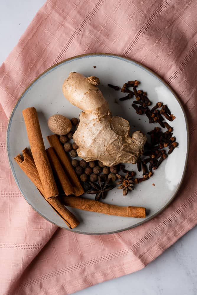 ginger, cloves, cinnamon, nutmeg, allspice, star anise on a pink napkin