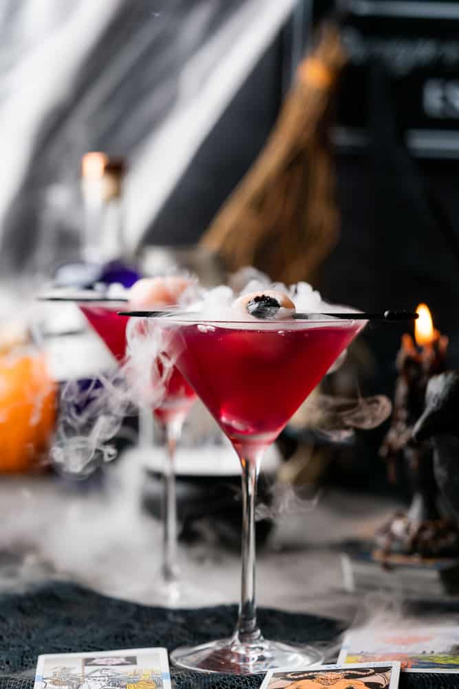smoking purple cocktail with eyeball black candle and pumpkins
