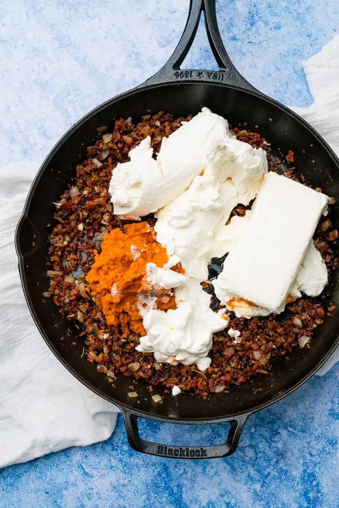 cream cheese goat cheese pumpkin puree and sour cream in a skillet with bacon