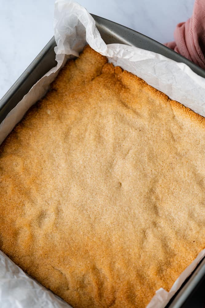 cooked shortbread crust in a pan with parchment
