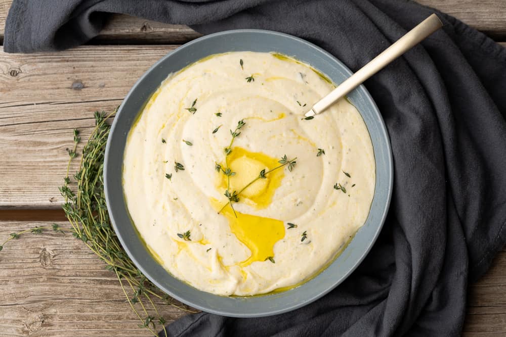 bowl of creamy mashed turnips with fresh thyme and melted butter