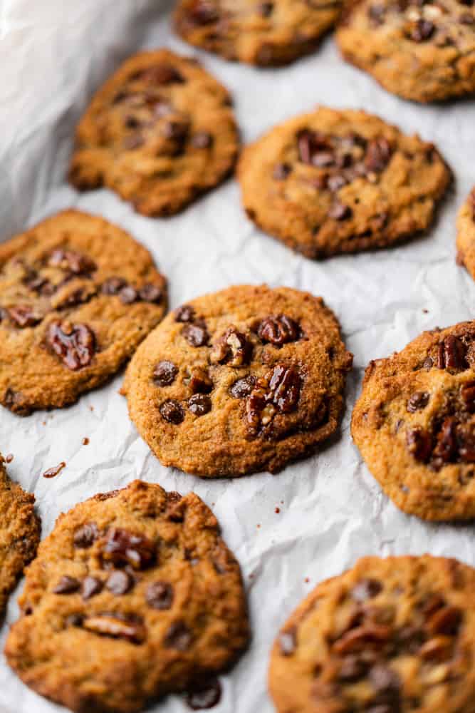 flatlay on white parchment paper of Keto Chocolate Chip Cookie Recipe with Candied Pecans