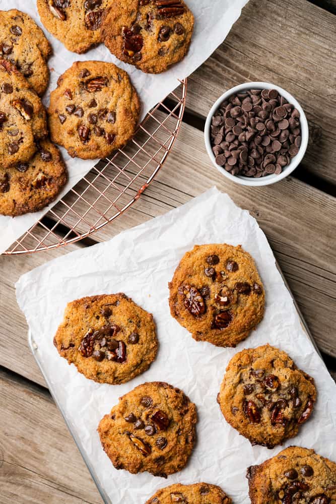 cookies on a drying rack with parchment and chocolate chips