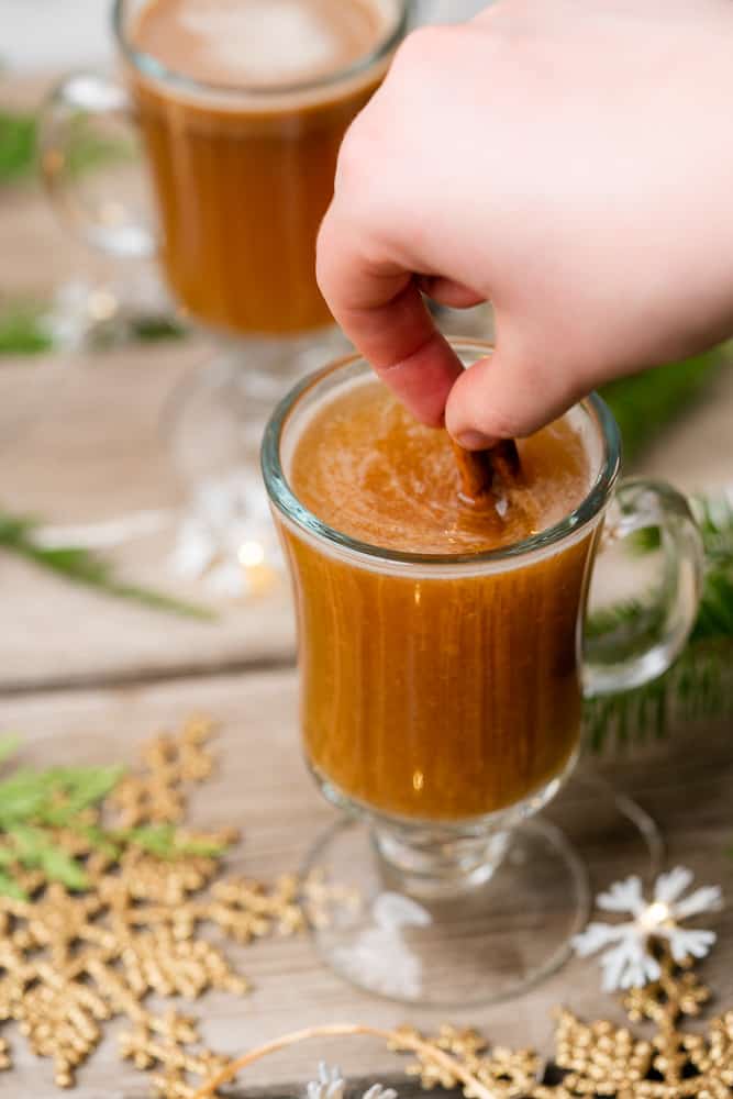 stirring hot buttered rum with a cinnamon stick