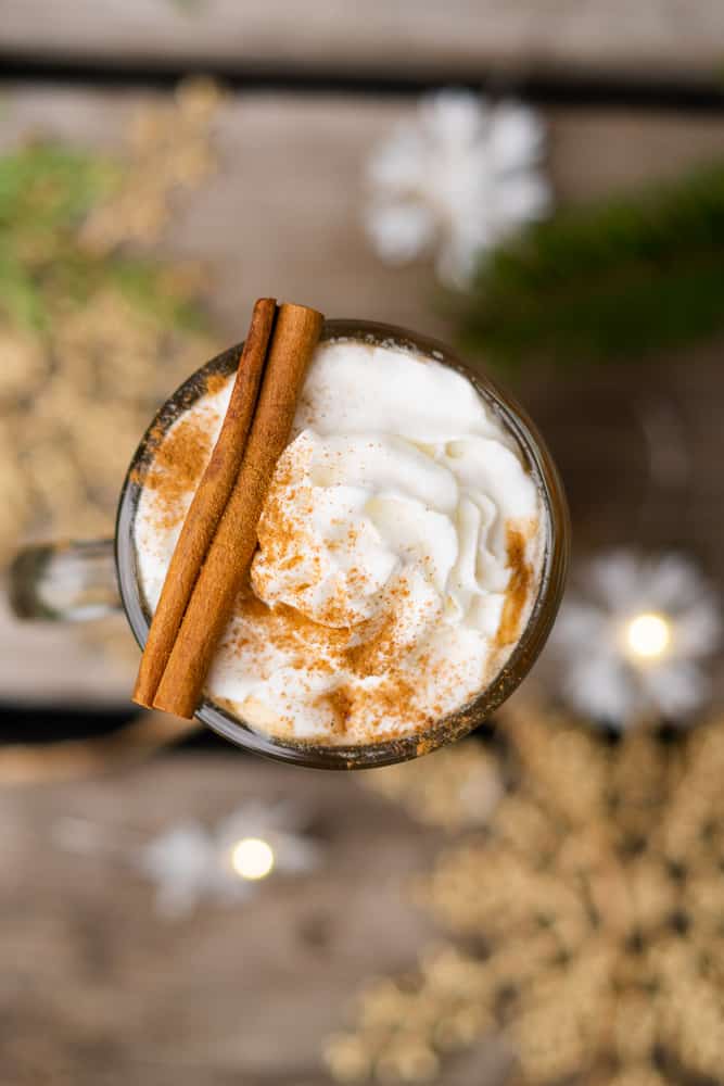 flat lay of hot buttered rum with a cinnamon stick and snowflakes