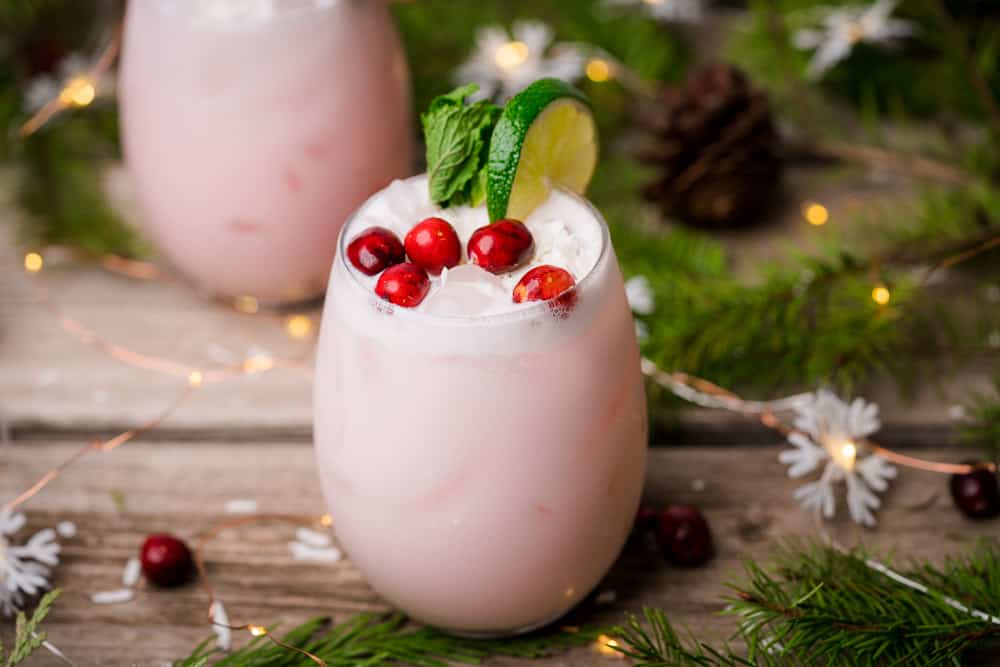 christmas cocktails with garland cranberries lights and mint