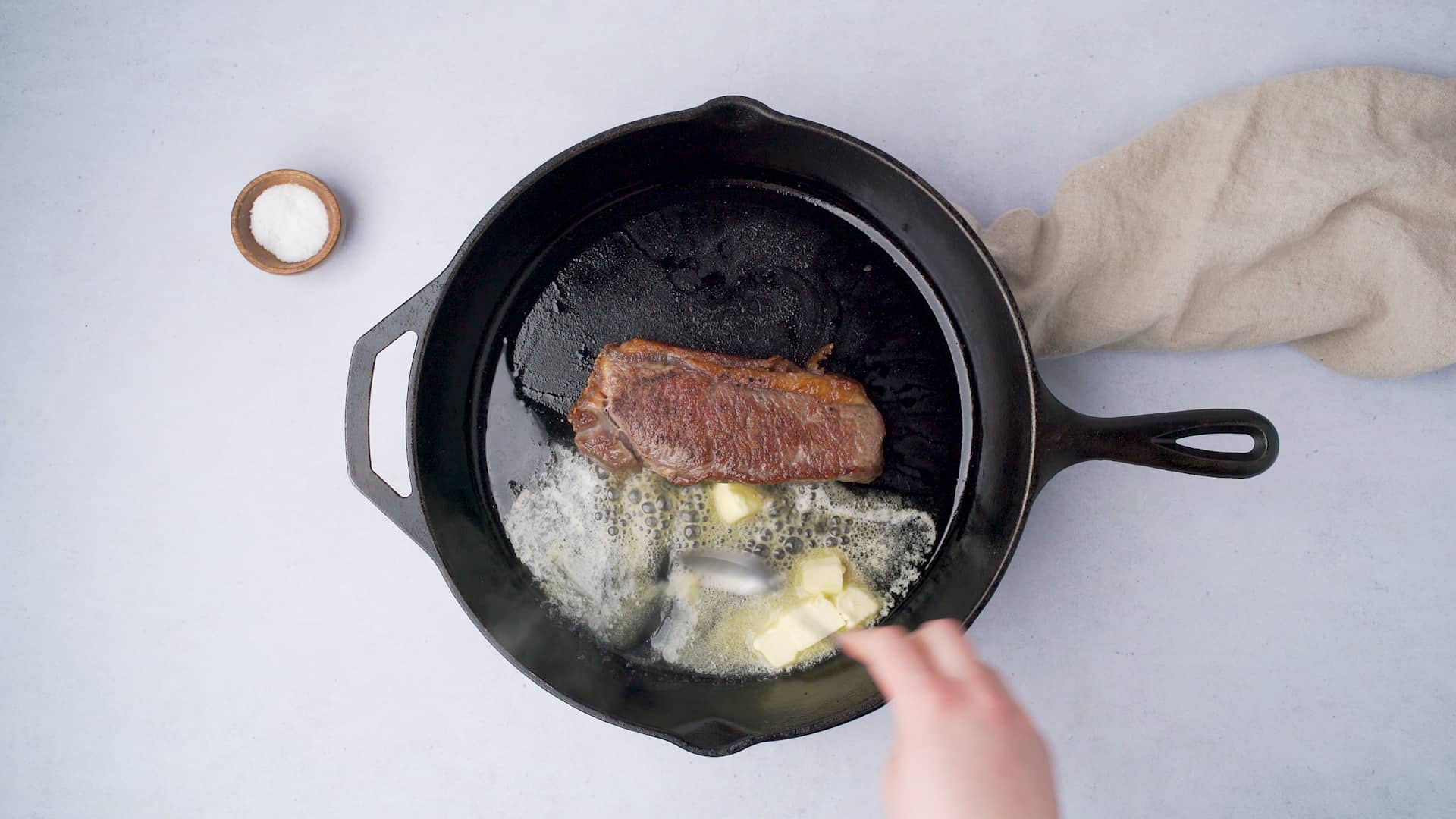 cooking a steak in a lodge cast iron skillet with butter