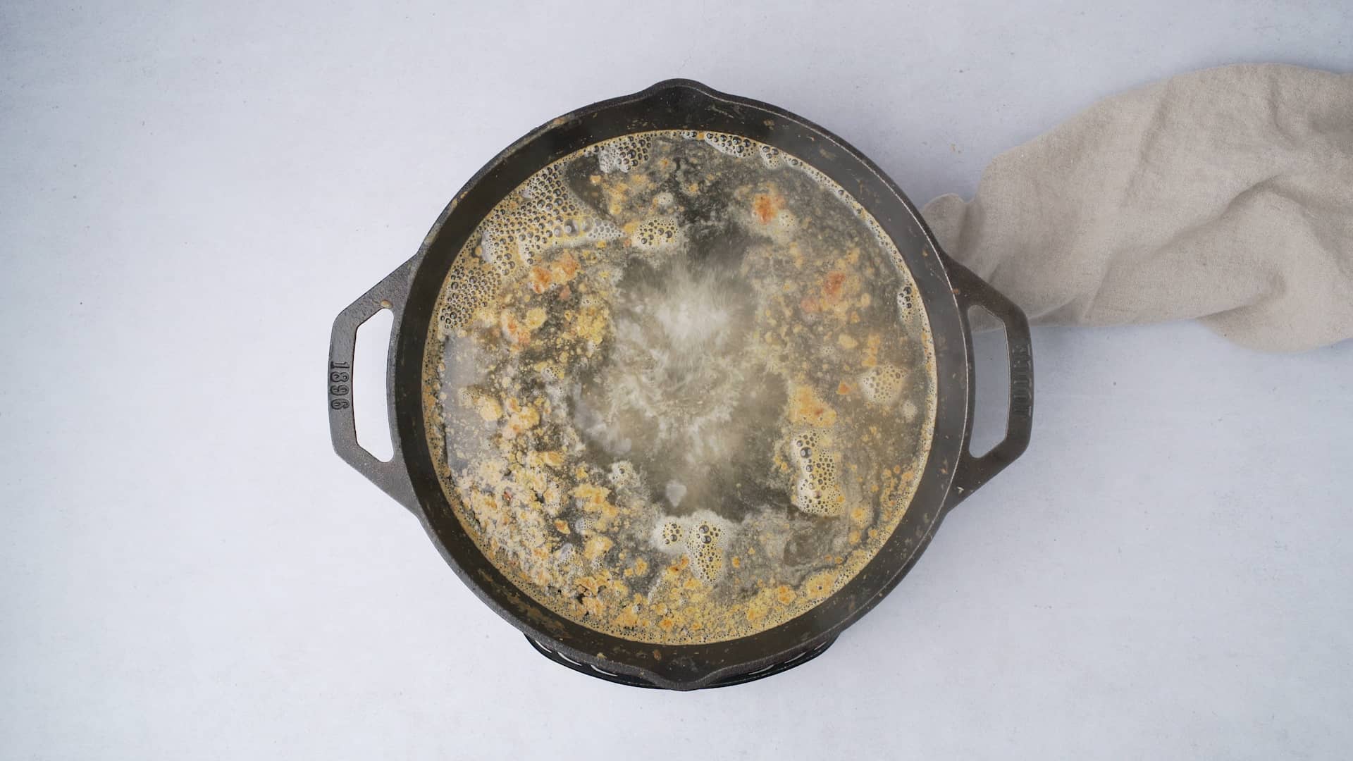 deglazing a cast iron pan with food in it 