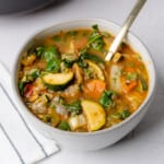 perfect bowl of veggie soup with a white and blue napkin