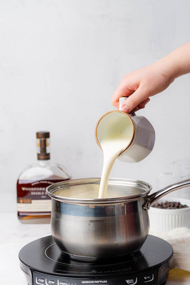 pouring heavy cream into a pan 