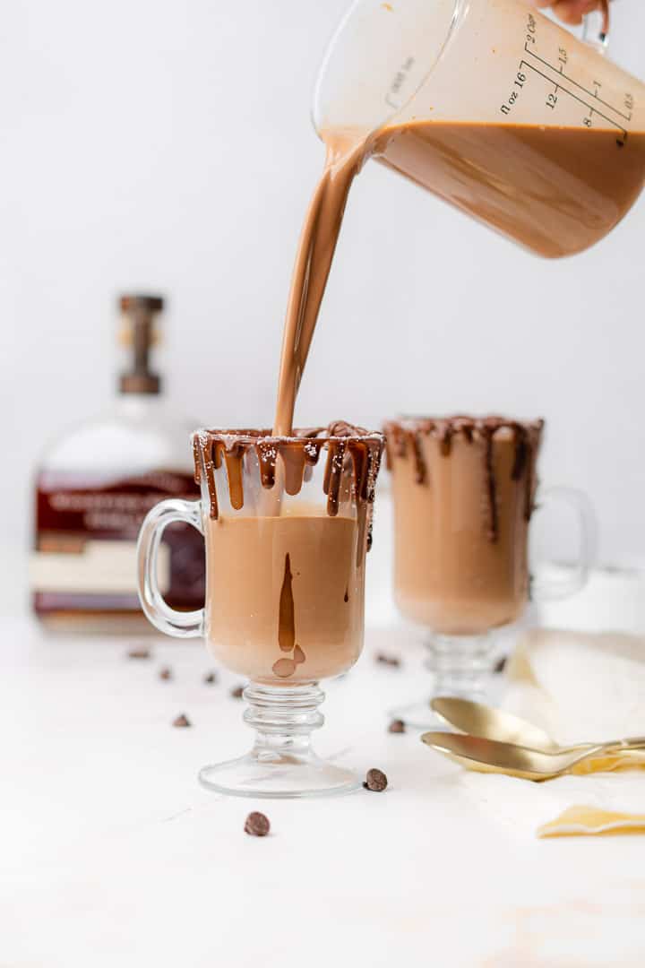 pouring hot cocoa into chocolate rimmed mugs