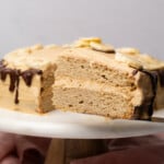 two layer slice of a banana dream cake with peanut butter frosting and a chocolate ganache