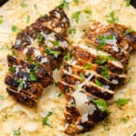two blackened cajun chicken breasts on a bed of creamy cajun chicken alfredo with parsley