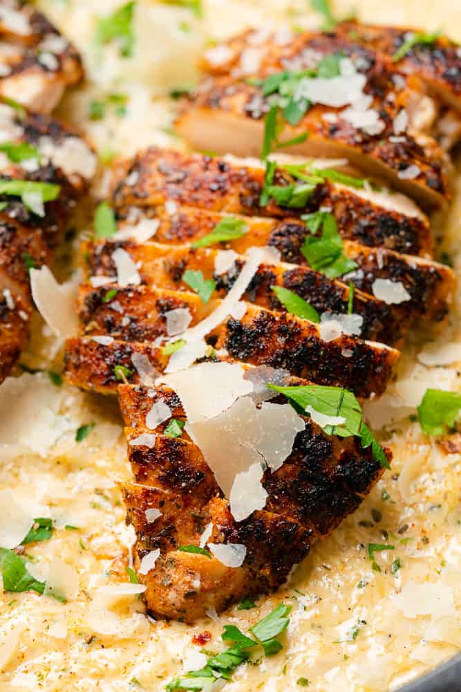 closeup shot of blackened cajun chicken with parsley and parmesan cheese