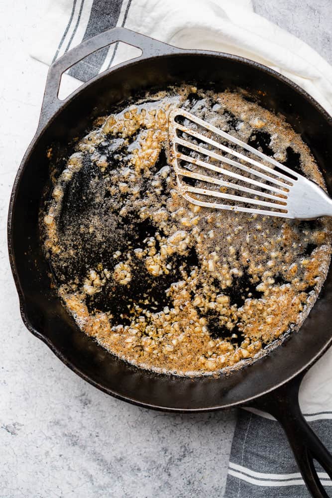 browned butter with garlic in a cast iron skillet with a metal spatula