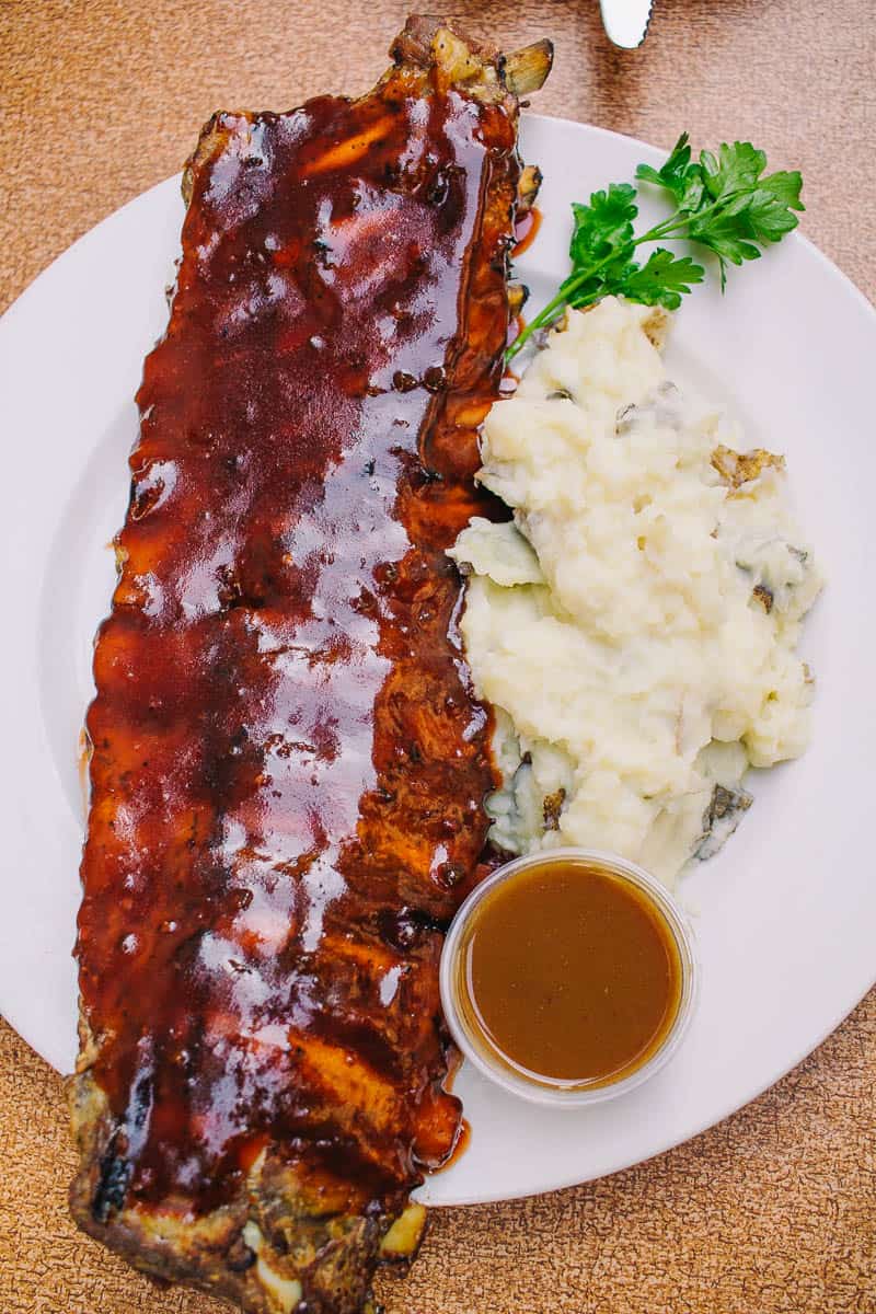 huge slab of bbq ribs with gravy and side of mashed potatoes