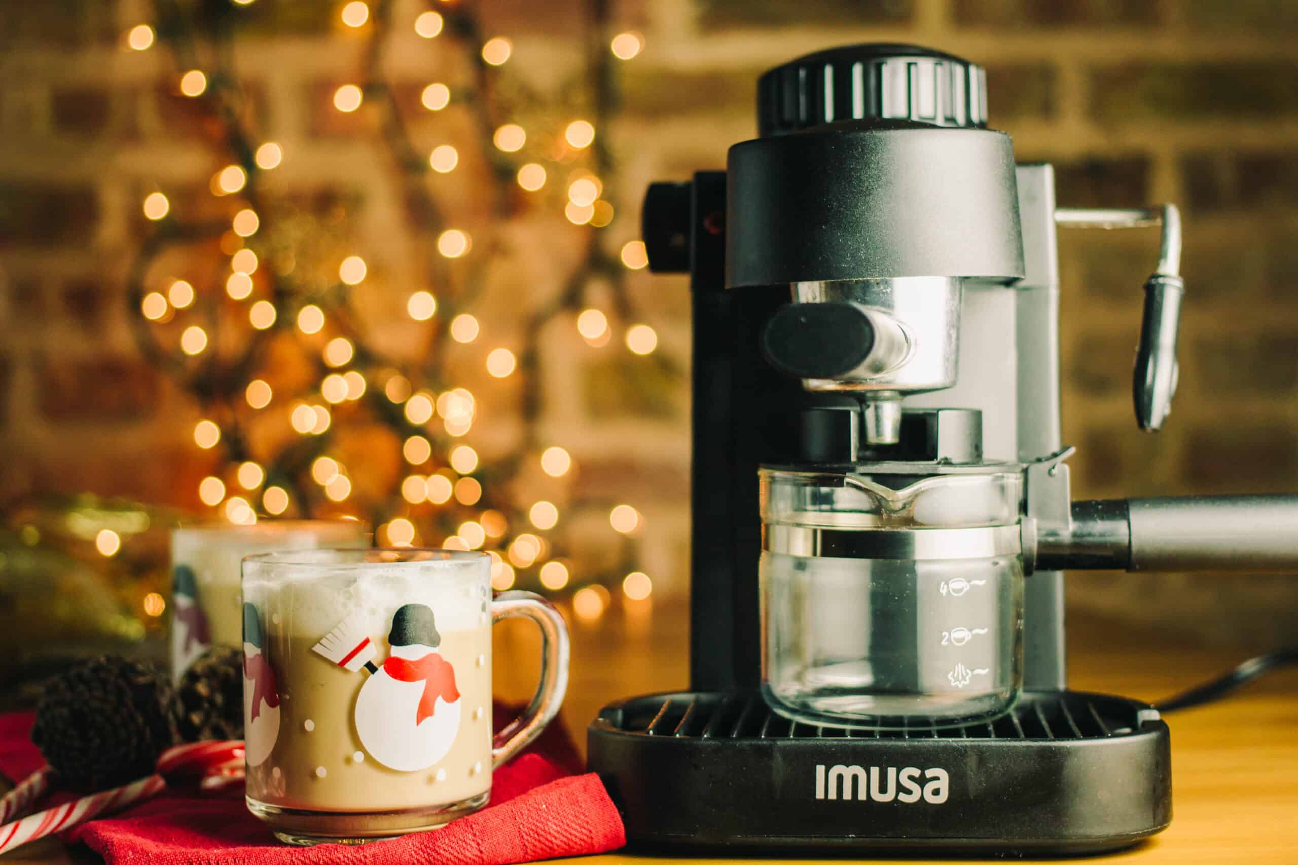 imusa espresso machine with twinkling lights in the background and snowmen mugs