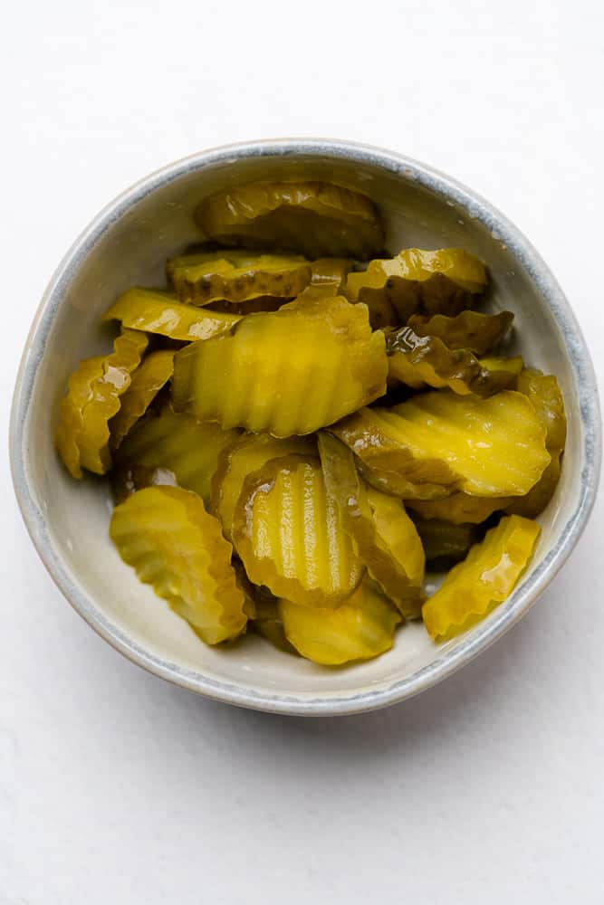 pickle chips in a small white dish