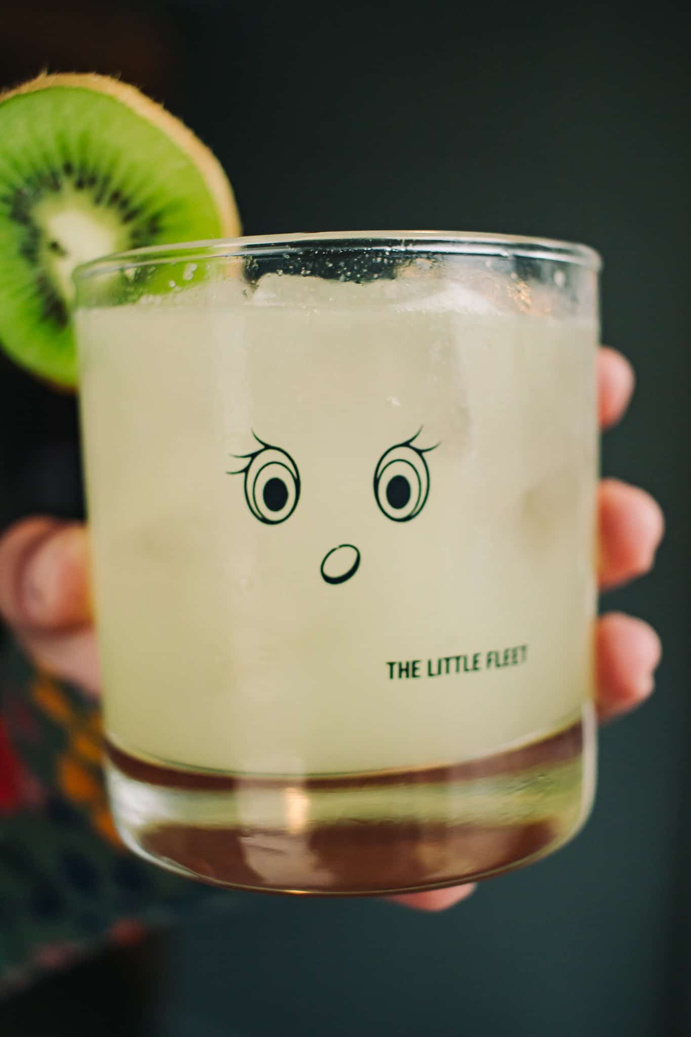 the signature glass at the little fleet with a slice of kiwi and a cute face on the glass