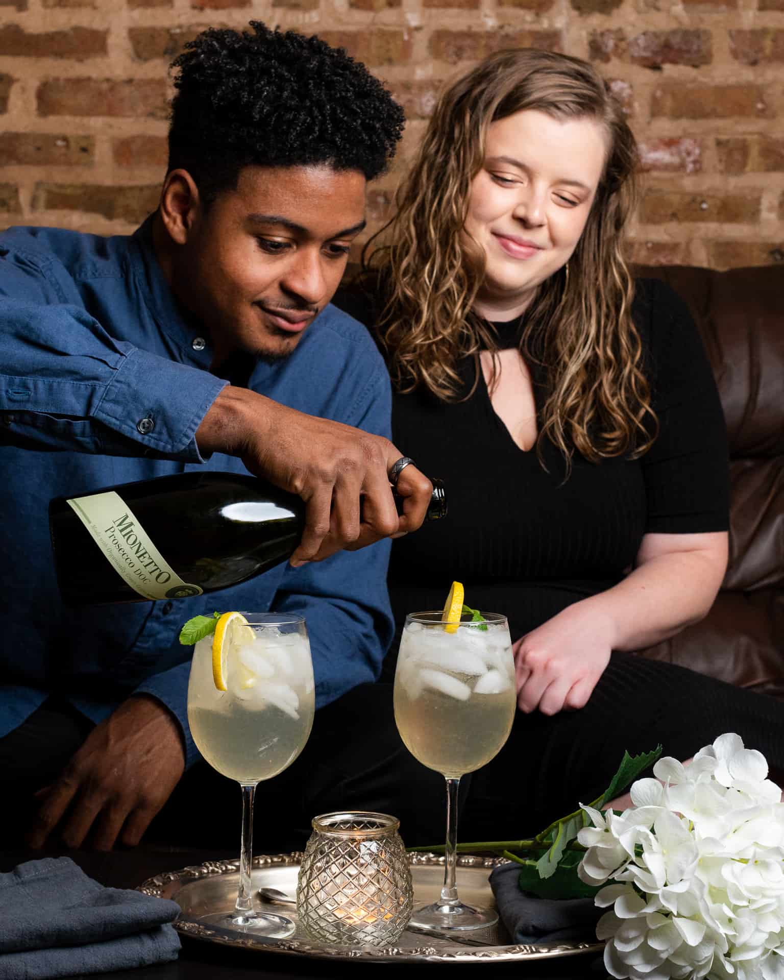 photo of man and woman sitting on a couch with two cocktail glasses