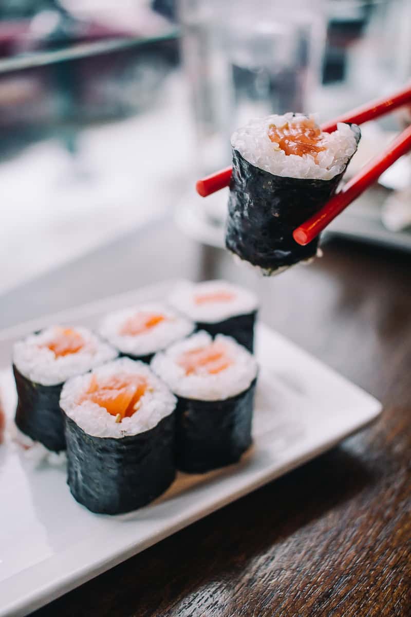 sushi being held up by chopsticks