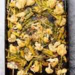 sheet cast iron pan of roasted cauliflower and asparagus