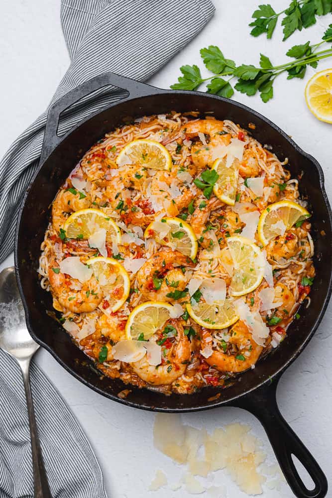 flat lay of shrimp and caramelized shallot pasta with low carb noodles in a cast iron skillet