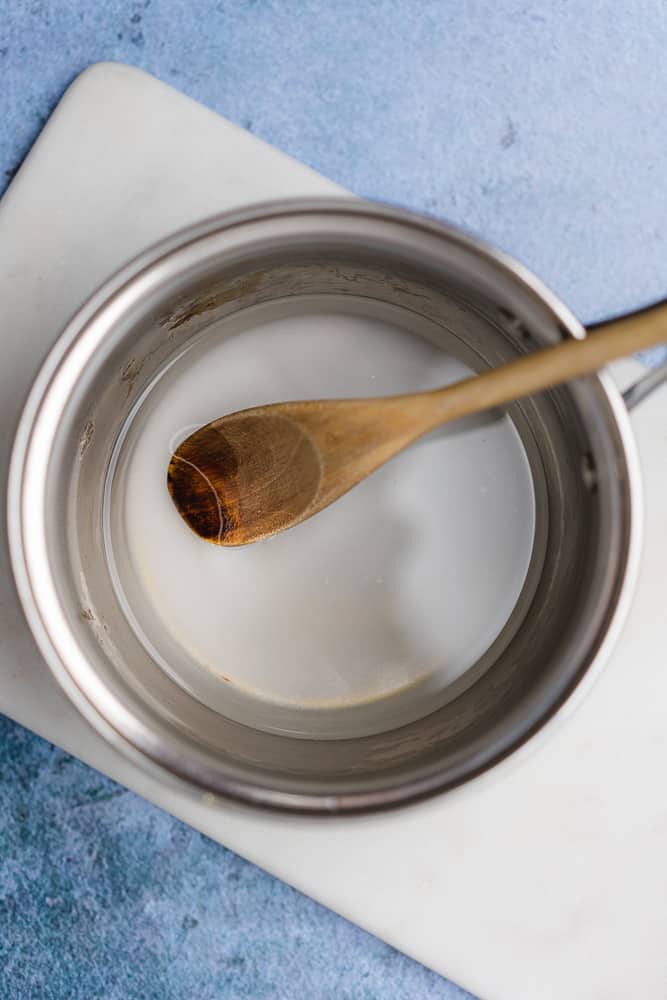 sugar free simple syrup in a sauce pan with a wooden spoon
