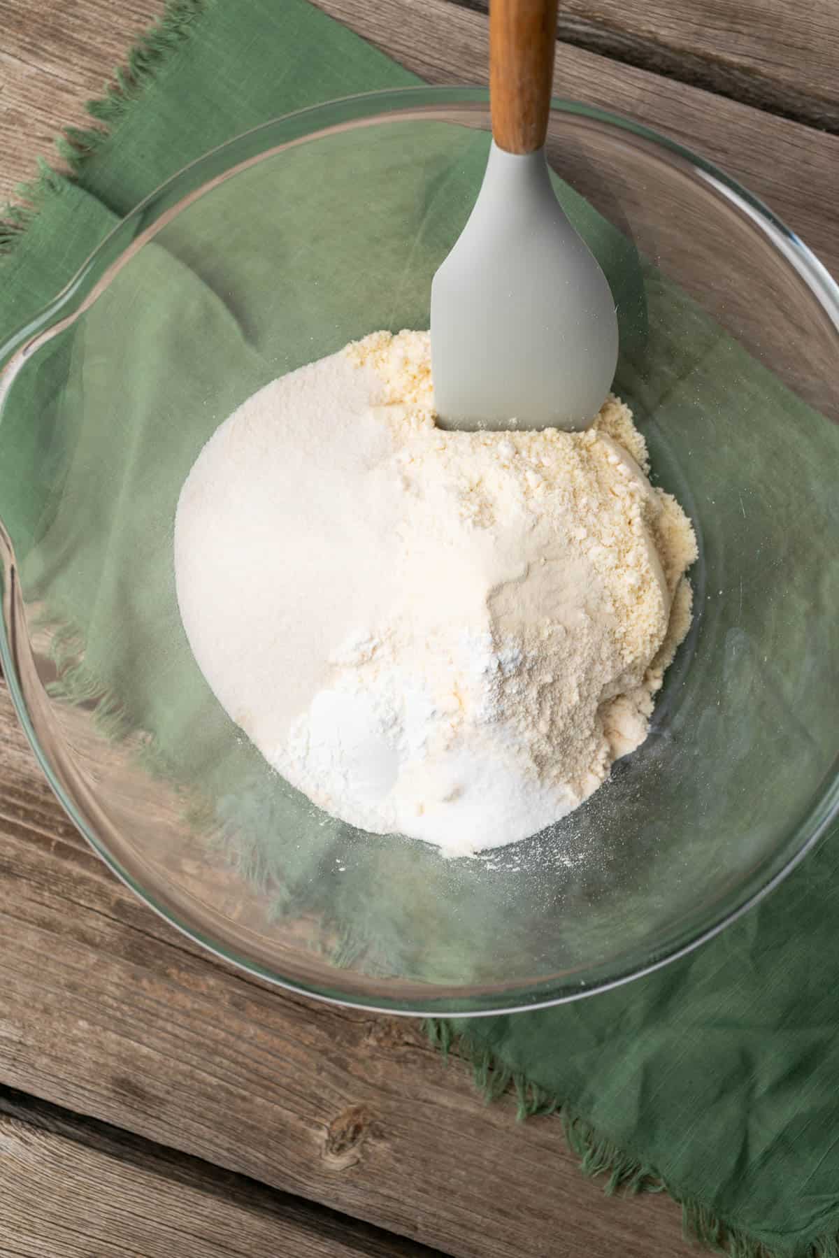 dry keto cornbread ingredients in a glass bowl with a green napkin underneath