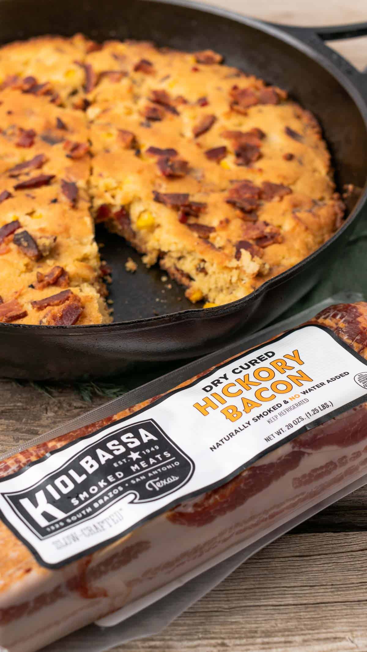 kiolbassa smoked meats hickory smoked bacon with a skillet of brown butter bacon cornbread in the background