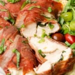 Chicken Stuffed with Mozzarella Wrapped in Parma Ham cut in half to see basil inside