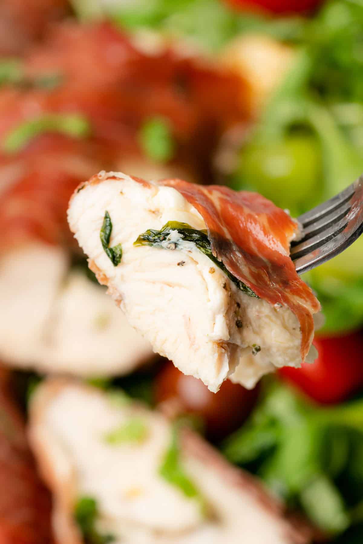 delicious and juicy forkful of chicken stuffed with mozzarella and wrapped in parma ham