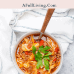 keto cabbage roll soup graphic with text with a bowl of bright red cabbage soup