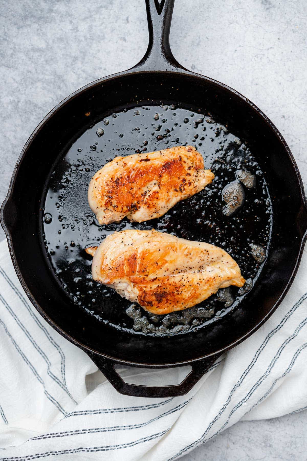 chicken searing in a cast iron skillet