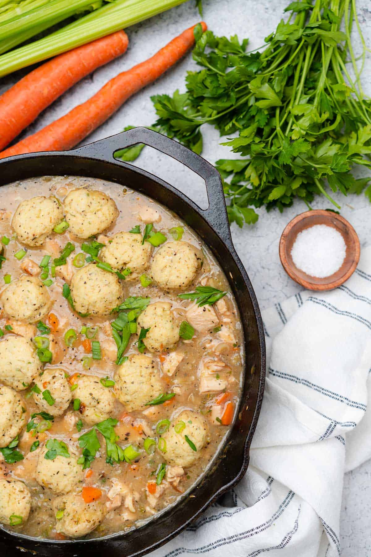 keto chicken and dumplings in a cast iron skillet with carrots and parsley