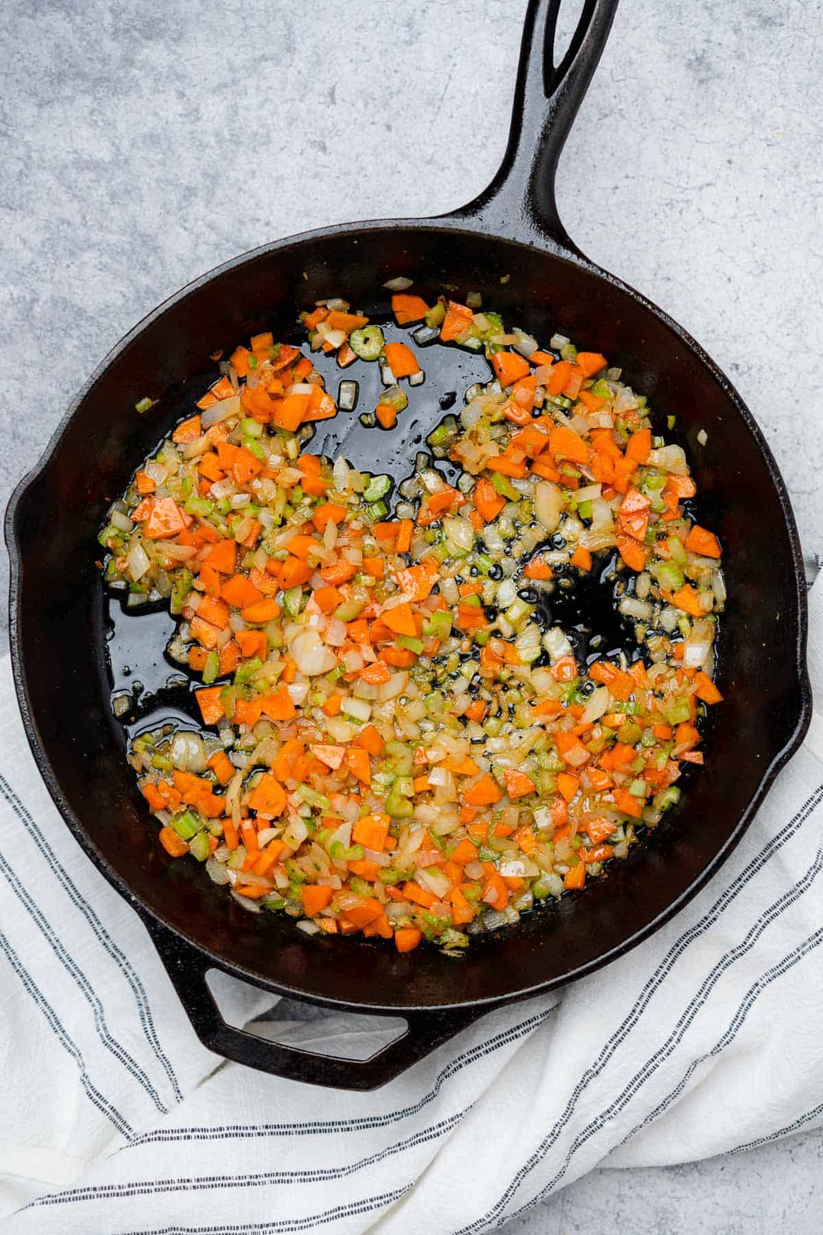 sauteed onion carrots and celery in a cast iron skillet