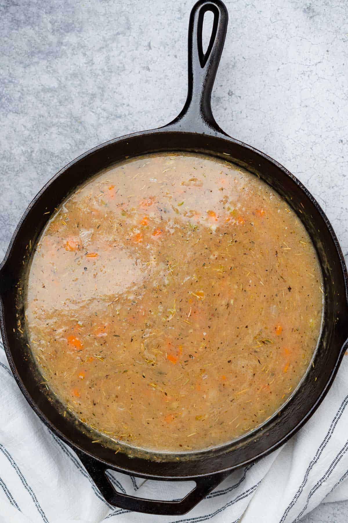 chicken and dumplings soup in a cast iron skillet