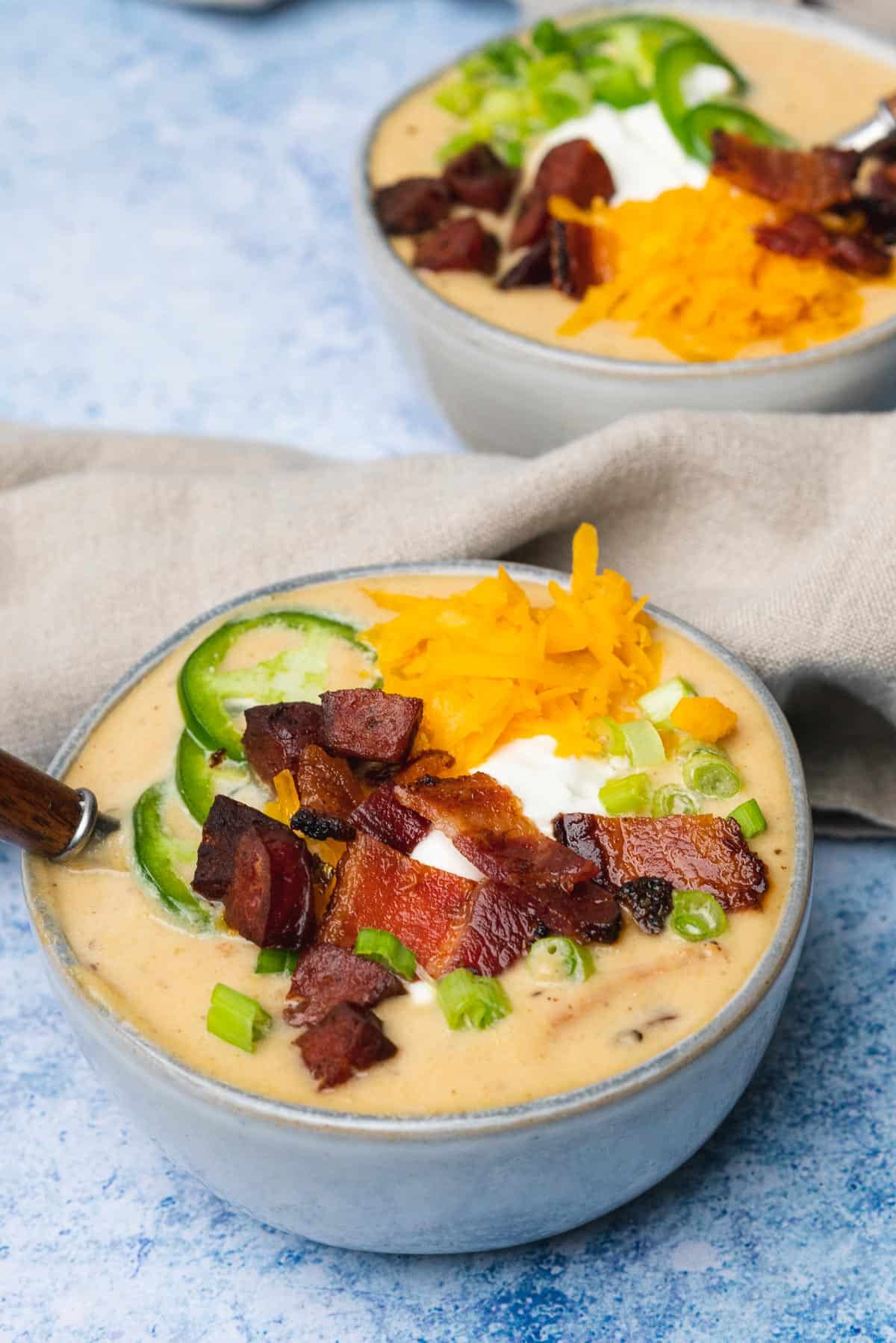 two bowls of loaded keto potato soup with bacon sour cream, cheese and jalapeños