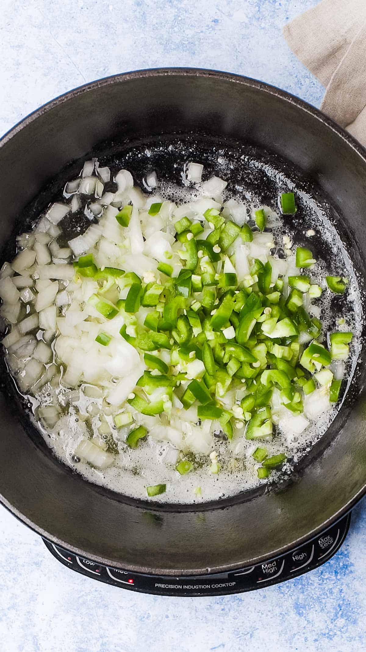 onions and jalapenos in a cast iron dutch oven