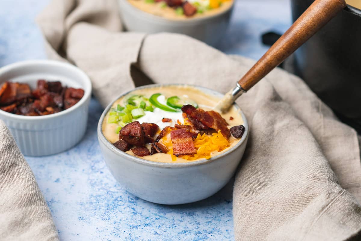 two pretty bowls of loaded keto potato soup with tons of toppings