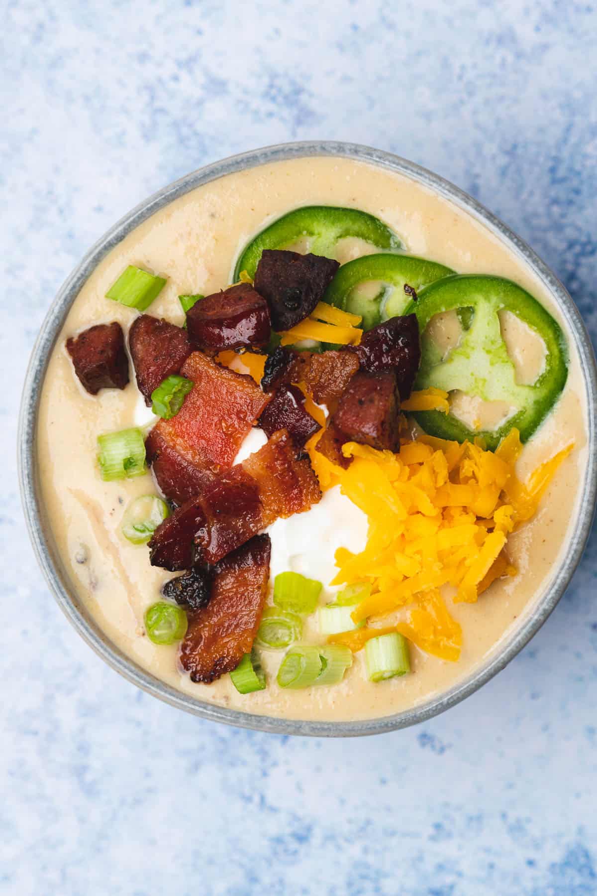 overehead shot of low carb potato soup loaded with bacon cheese sour cream green onion and jalapenos