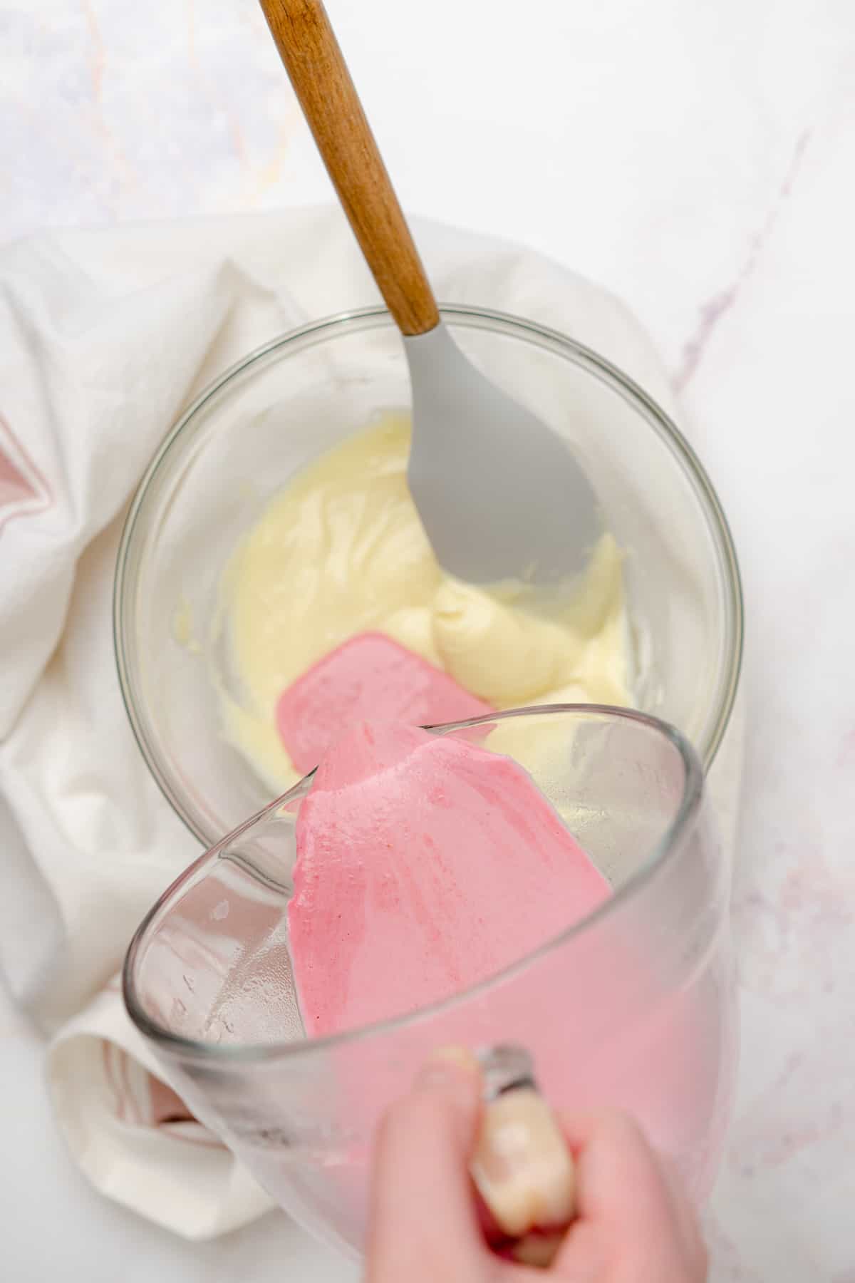 pouring pink raspberry and heavy cream mixture to melted chocolate mixture