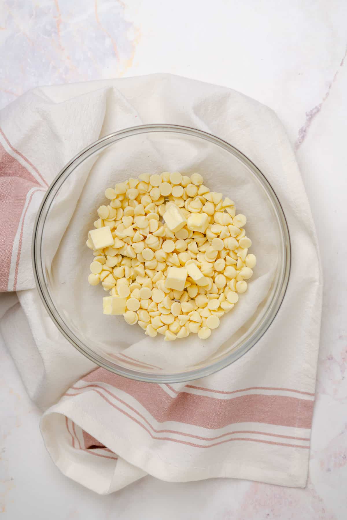 white chocolate chips with butter in a glass bowl